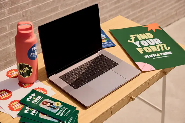 Branded flyers and stickers beside a laptop